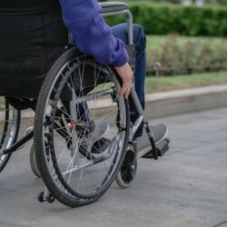 Rollstuhlfahrer auf dem Bürgersteig
